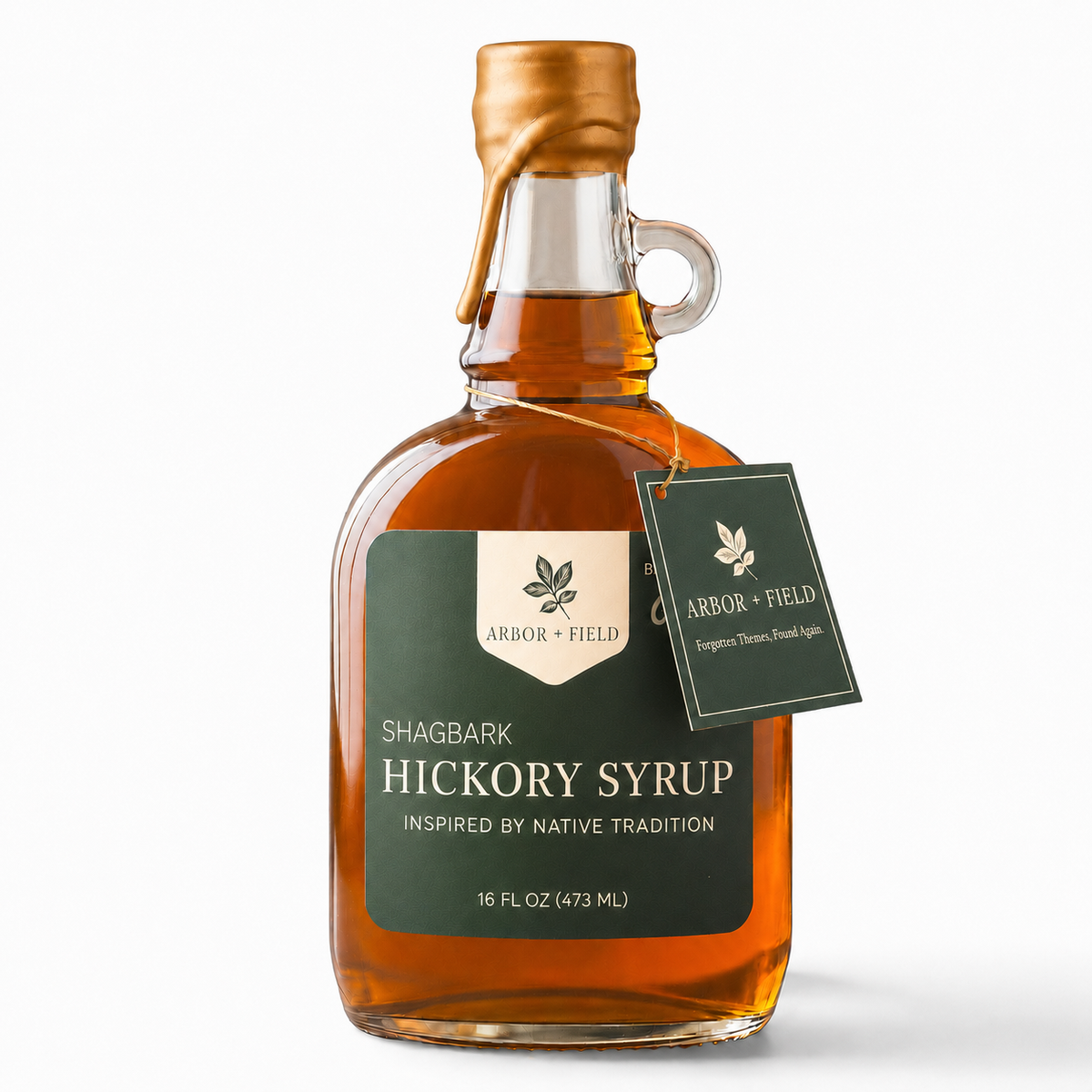 Shagbark Hickory Syrup 16 oz growler bottle with green and cream Arbor and Field Label on the front, a gold wax dipped cap and dark green gift tag hanging around the neck of the bottle  from a gold string. Clean white background, premium look and feel. 