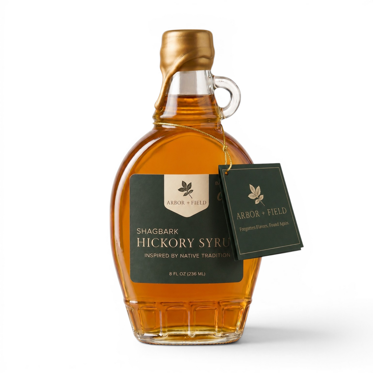 Shagbark Hickory Syrup 8 oz flask bottle with green and cream Arbor and Field Label on the front, a gold wax dipped cap and dark green gift tag hanging around the neck of the bottle  from a gold string. Clean white background, premium look and feel. 